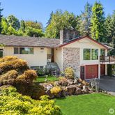 a front view of a house with a garden and plants