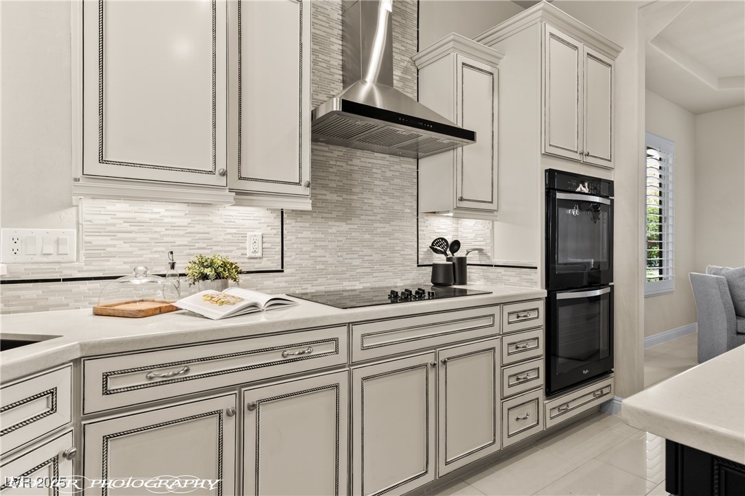 1348 Basin View Mesquite, NV 89034 - Photo 17 of 70 Kitchen featuring wall chimney range hood, decorative backsplash, black appliances, and light tile patterned floors