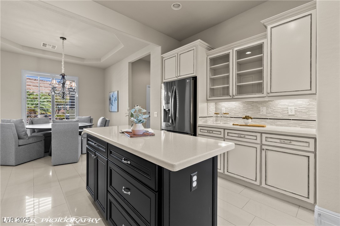 1348 Basin View Mesquite, NV 89034 - Photo 22 of 70 Kitchen featuring glass insert cabinets, tasteful backsplash, a center island, stainless steel fridge with ice dispenser, and hanging light fixtures