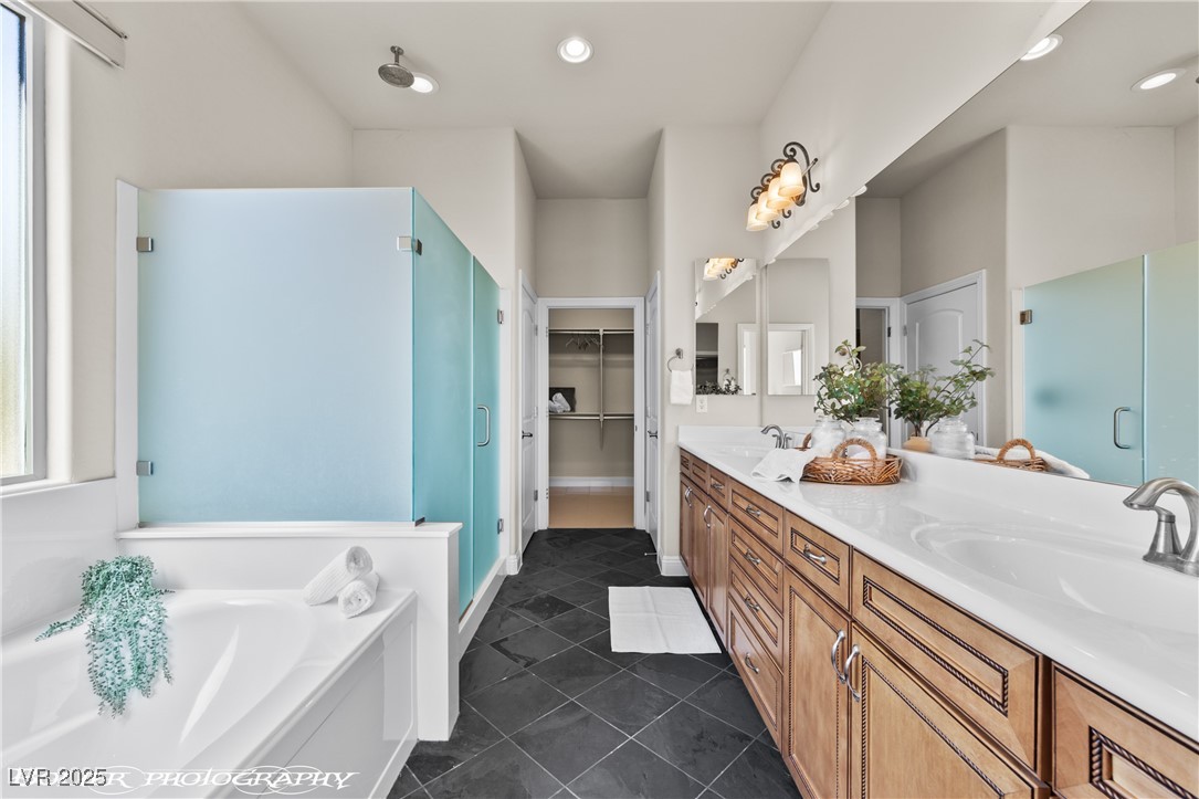 1348 Basin View Mesquite, NV 89034 - Photo 37 of 70 Full bathroom with a stall shower, a spacious closet, double vanity, dark tile patterned flooring, and a bath