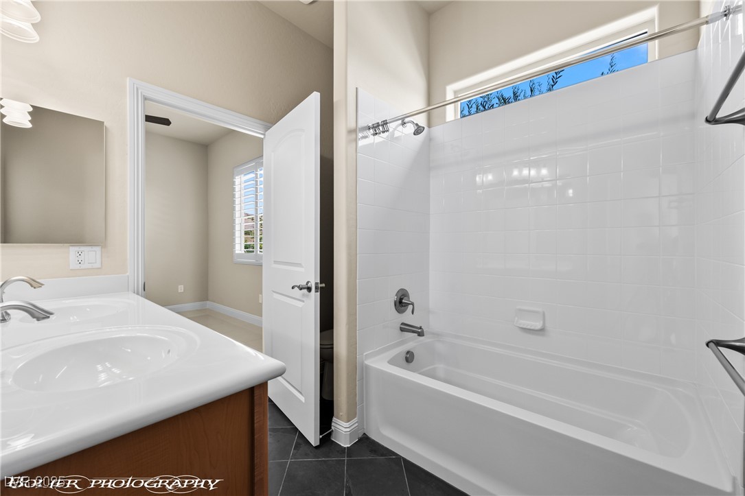 1348 Basin View Mesquite, NV 89034 - Photo 45 of 70 Bathroom featuring tub / shower combination, dark tile patterned floors, and double vanity