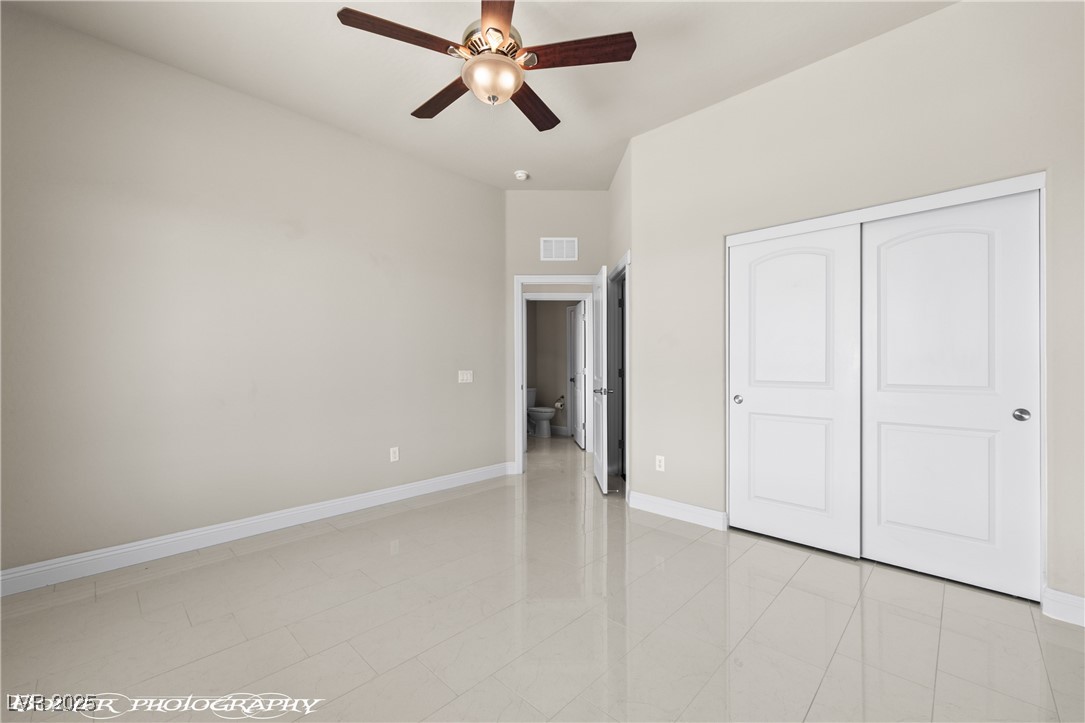 1348 Basin View Mesquite, NV 89034 - Photo 47 of 70 Unfurnished bedroom with ceiling fan, light tile patterned floors, and a closet