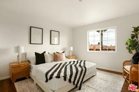 a bedroom with a bed and wooden floor