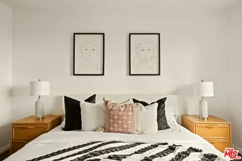 a bedroom with a bed and painting on the wall