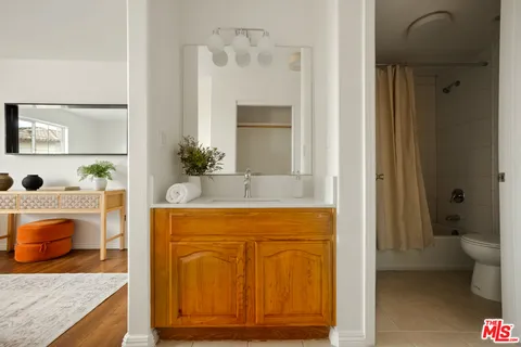 a bathroom with a granite countertop sink and a bathtub