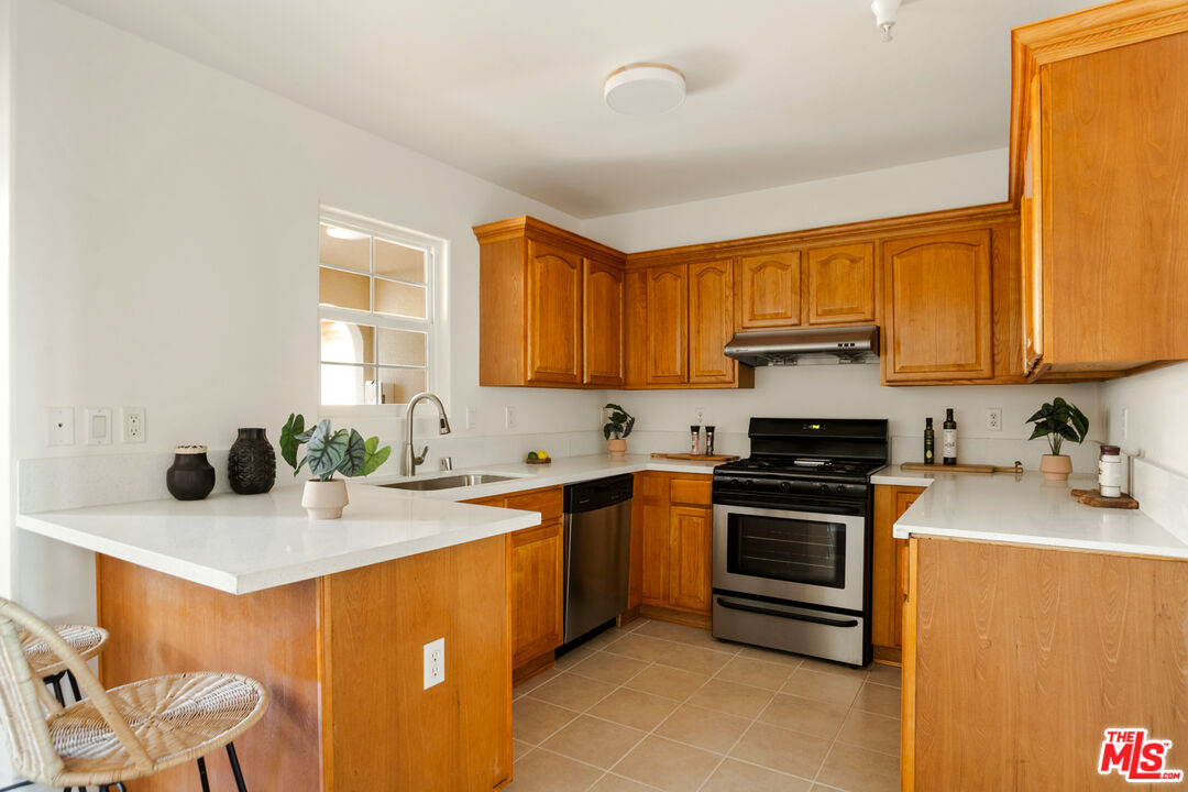 3711 Baldwin Street, Unit 1306 Los Angeles, CA 90031 - Photo 9 of 35 a kitchen with stainless steel appliances granite countertop a sink stove and cabinets