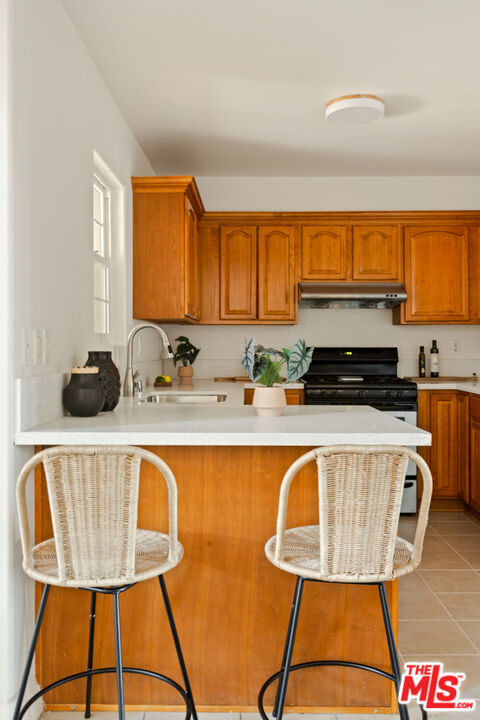 3711 Baldwin Street, Unit 1306 Los Angeles, CA 90031 - Photo 10 of 35 a kitchen with a sink a stove and a wooden cabinets