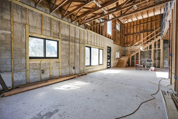 a view of an empty room with wooden floor and door