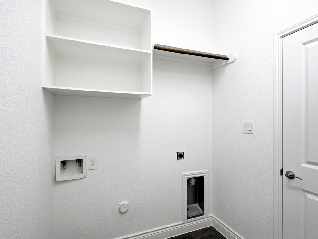 109 Lake Spring Circle Georgetown, TX 78633 - Photo 32 of 38 Functional laundry space includes convenient shelving and a practical hanging rod for organization.