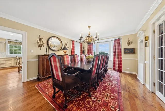 a view of a dining room with furniture a chandelier and wooden floor