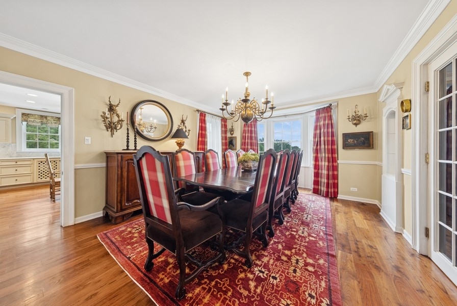 6191 South County Line Road Burr Ridge, IL 60527 - Photo 15 of 38 a view of a dining room with furniture a chandelier and wooden floor