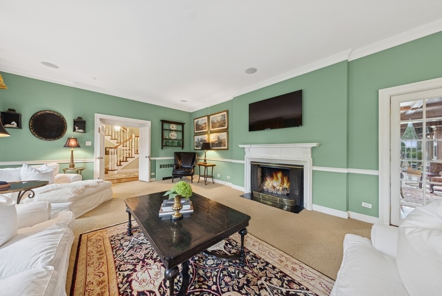 6191 South County Line Road Burr Ridge, IL 60527 - Photo 17 of 38 a living room with furniture a flat screen tv and a fireplace