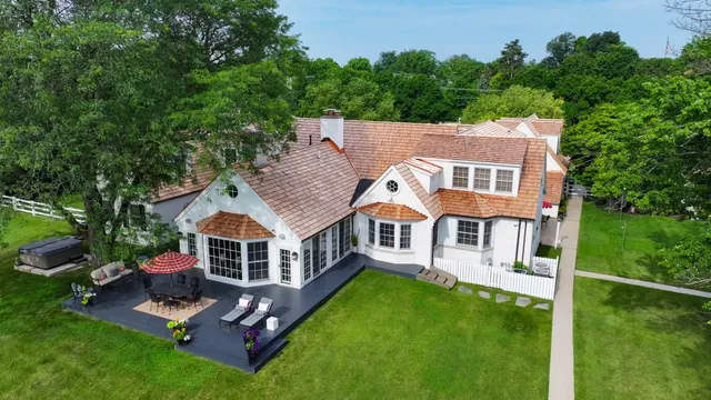 an aerial view of a house with swimming pool next to a big yard