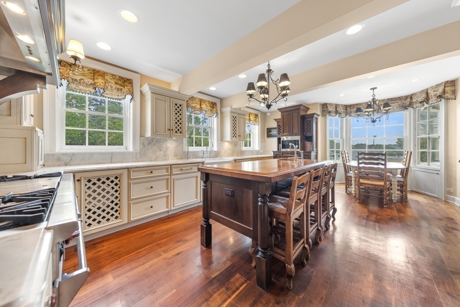 6191 South County Line Road Burr Ridge, IL 60527 - Photo 8 of 38 a kitchen with a table chairs stove and cabinets