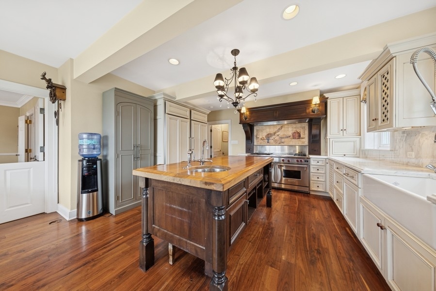 6191 South County Line Road Burr Ridge, IL 60527 - Photo 9 of 38 a kitchen with a stove and wooden floor