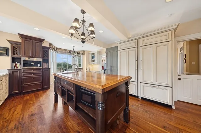 a room with stainless steel appliances granite countertop a stove a refrigerator and a wooden floors