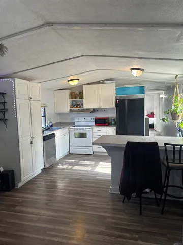 a living room with stainless steel appliances furniture or kitchen view and a refrigerator