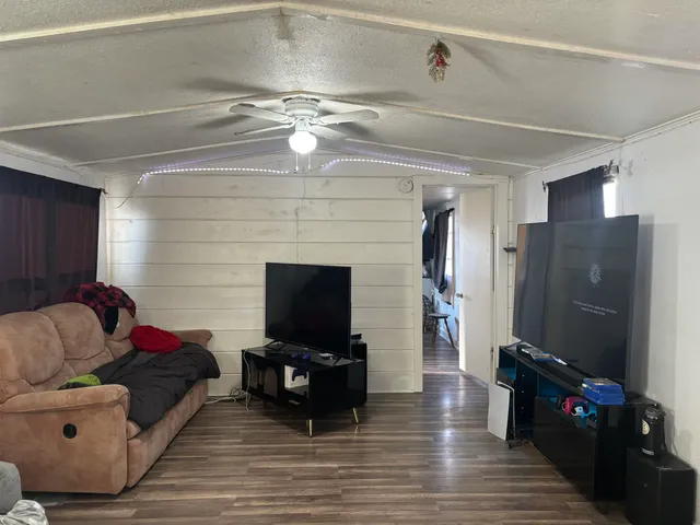 a living room with furniture a flat screen tv and a fireplace