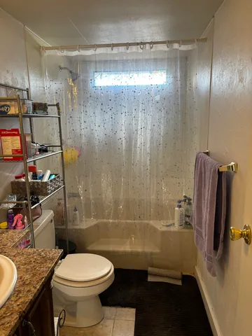 a bathroom with a granite countertop toilet sink and shower