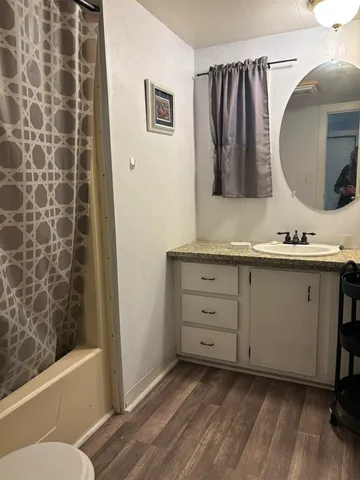 a bathroom with a granite countertop sink toilet and shower