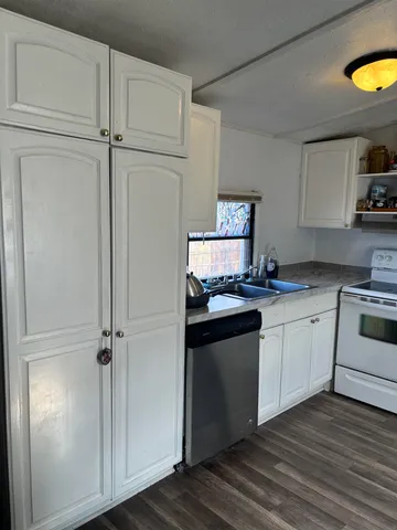 a kitchen with granite countertop a sink cabinets and stainless steel appliances