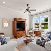 a living room with furniture ceiling fan and a window