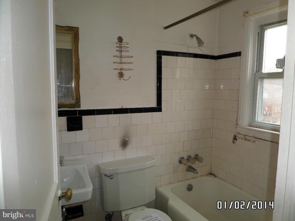 4506 Fairfax Road Baltimore, MD 21216 - Photo 17 of 28 a bathroom with a shower a toilet and sink