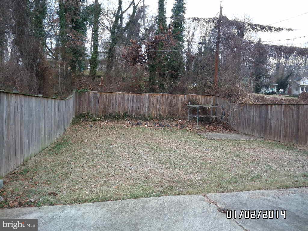 4506 Fairfax Road Baltimore, MD 21216 - Photo 27 of 28 a view of backyard with wooden fence and trees