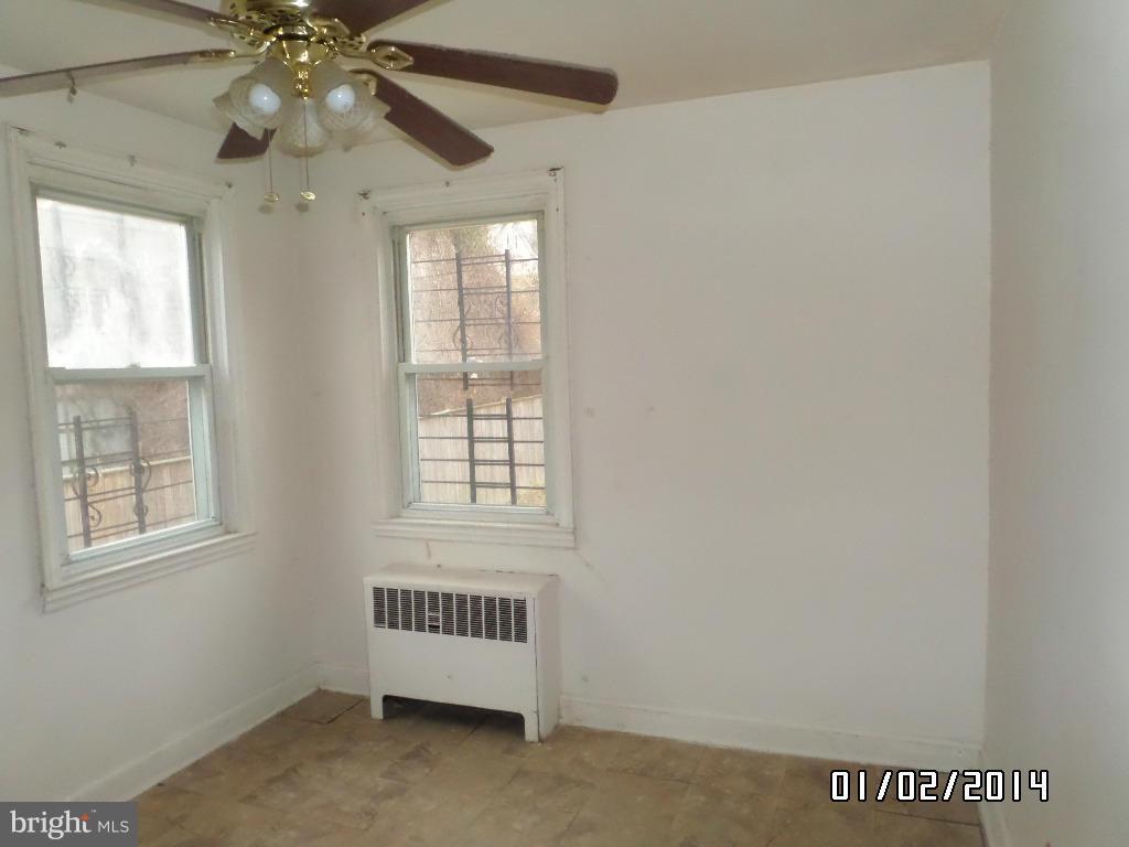 4506 Fairfax Road Baltimore, MD 21216 - Photo 8 of 28 an empty room with windows and fan