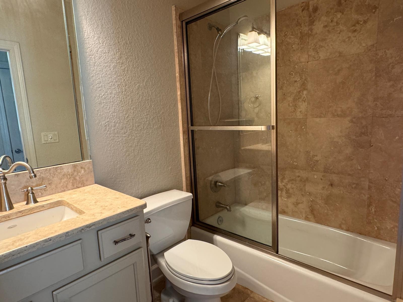 241 Inverrary Drive Destin, FL 32541 - Photo 20 of 24 a bathroom with a granite countertop toilet a sink and a mirror