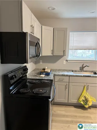 a kitchen with granite countertop a stove and a sink