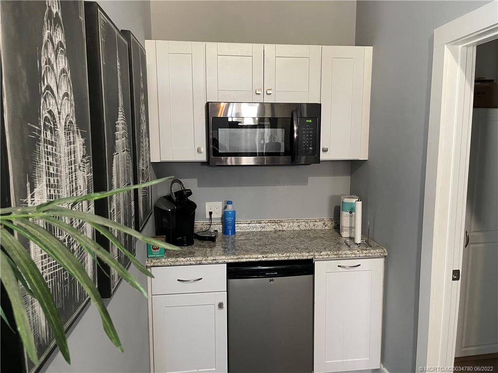 431 Northeast Baker Road Stuart, FL 34994 - Photo 5 of 11 a kitchen with a sink a stove and a microwave