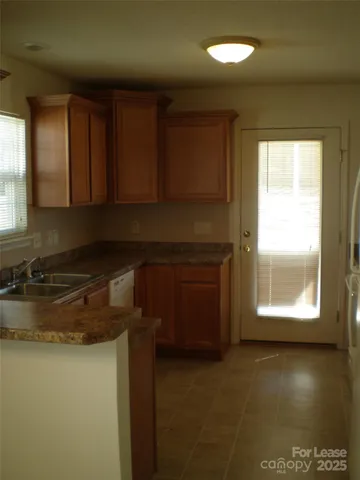 a kitchen with a window a sink and a microwave