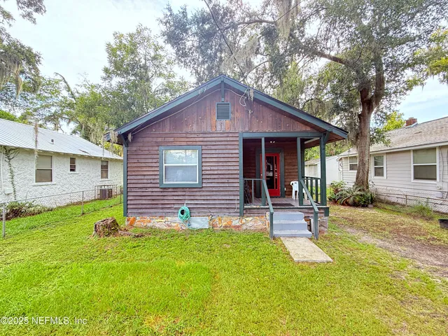 a view of a house with a yard and sitting area