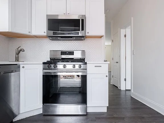 1524 North Ashland Avenue Chicago, IL 60622 - Photo 14 of 38 a kitchen with stainless steel appliances a stove a microwave and sink