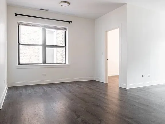 a view of a small space with wooden floor and a window