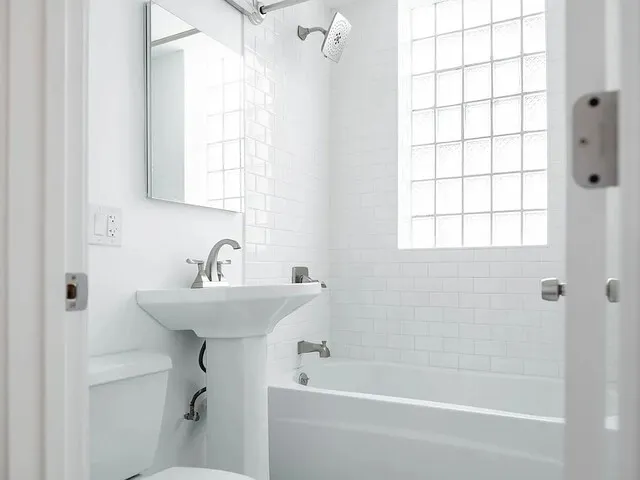an empty room with wooden floor cabinet and windows