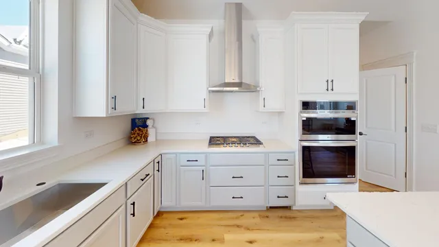 a kitchen with white cabinets and appliances