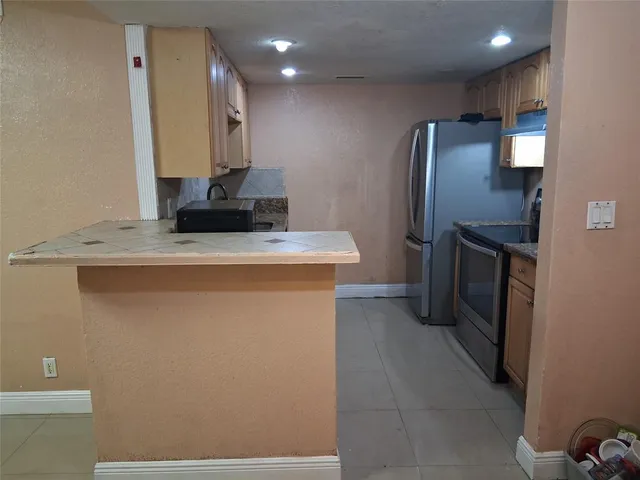 a kitchen with granite countertop a sink stainless steel appliances and cabinets