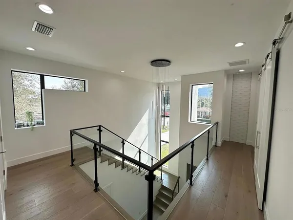 a view of a hallway with wooden floor and stairs