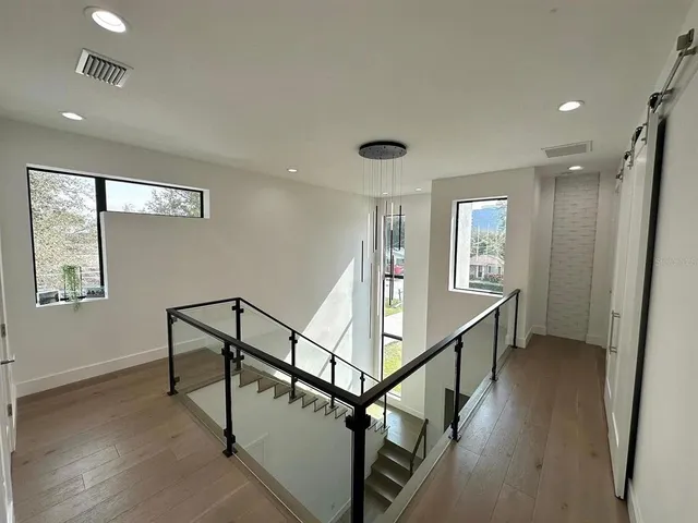 a view of a hallway with wooden floor and stairs