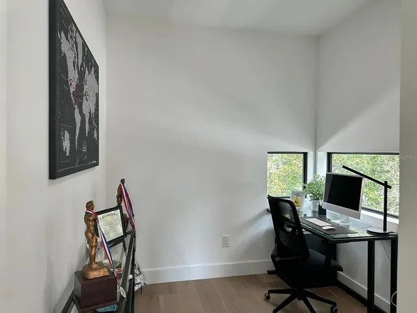 a view of a workspace with furniture and a window