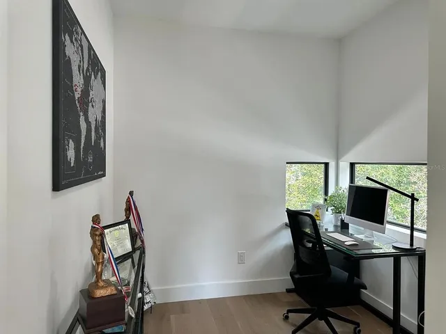 a view of a workspace with furniture and a window