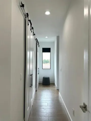 a view of a hallway with wooden floor and glass door
