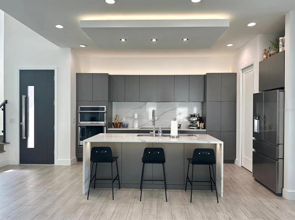 4217 West Arch Street Tampa, FL 33607 - Photo 3 of 22 a kitchen with stainless steel appliances a table chairs refrigerator and cabinets