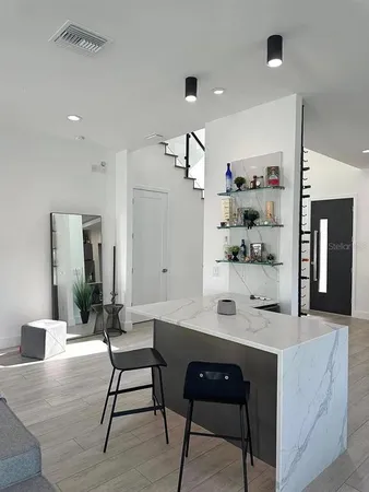a dining hall with stainless steel appliances kitchen island granite countertop a table and chairs in it