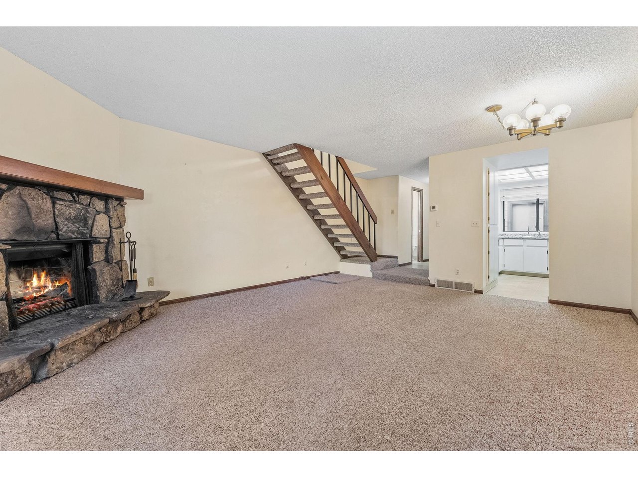 1325 Birch Street, Unit 12 Fort Collins, CO 80521 - Photo 14 of 26 a view of an empty room with chandelier fan and fireplace