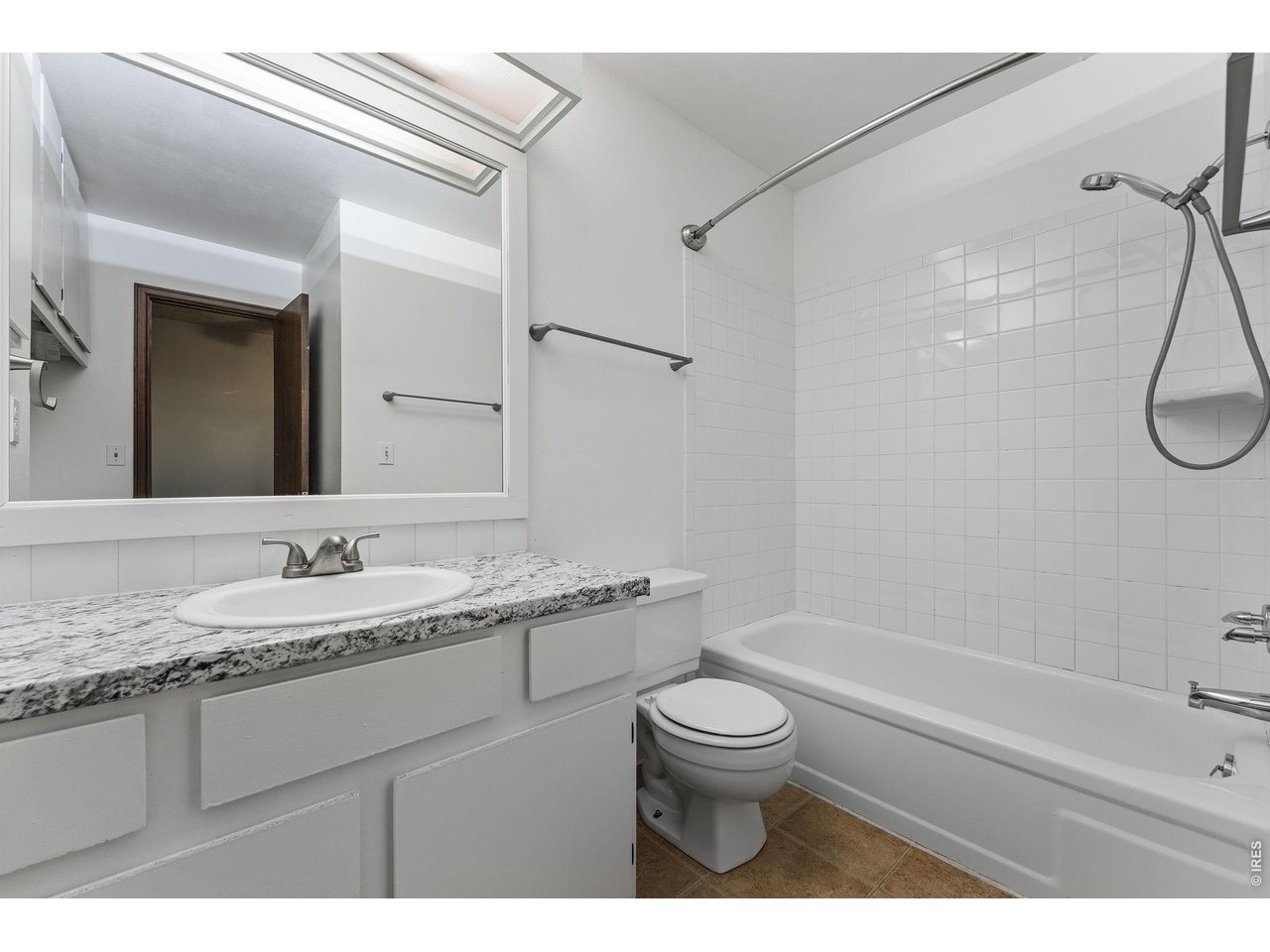 1325 Birch Street, Unit 12 Fort Collins, CO 80521 - Photo 22 of 26 a bathroom with a granite countertop sink toilet a mirror and shower