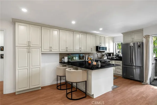 a kitchen with a refrigerator and a stove top oven