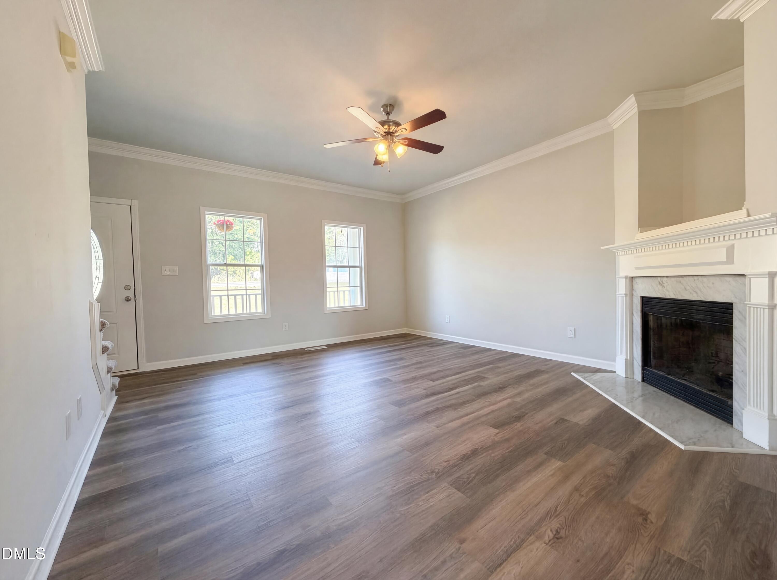 1071 Darius Pearce Road Youngsville, NC 27596 - Photo 3 of 22 an empty room with windows fireplace and a kitchen view